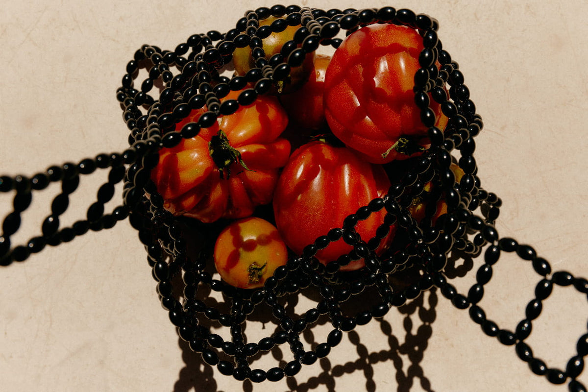 Black beaded basket of orange fruit