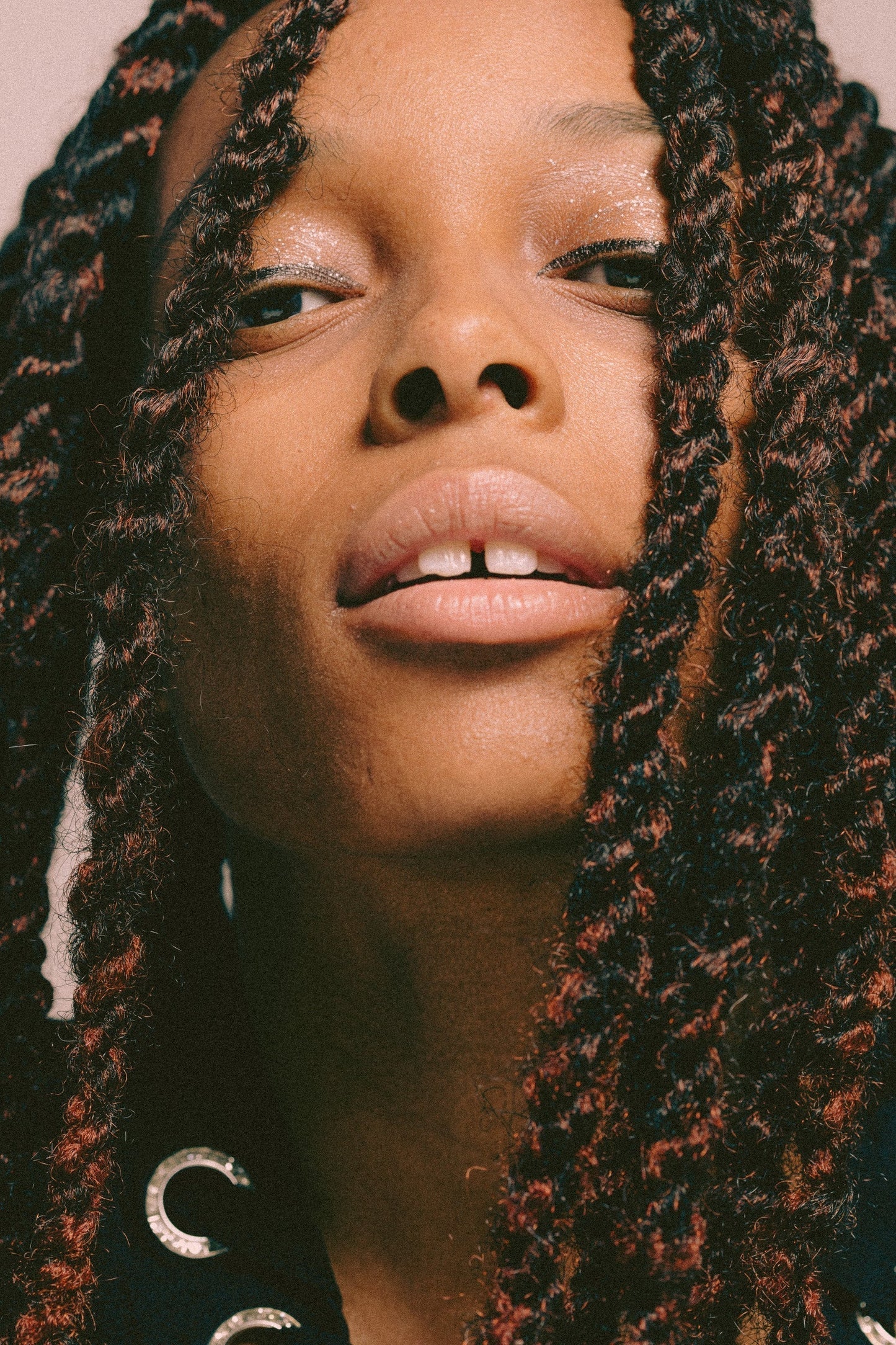 up close of black woman's face with brown twists, nude lipstick, and black eye liner