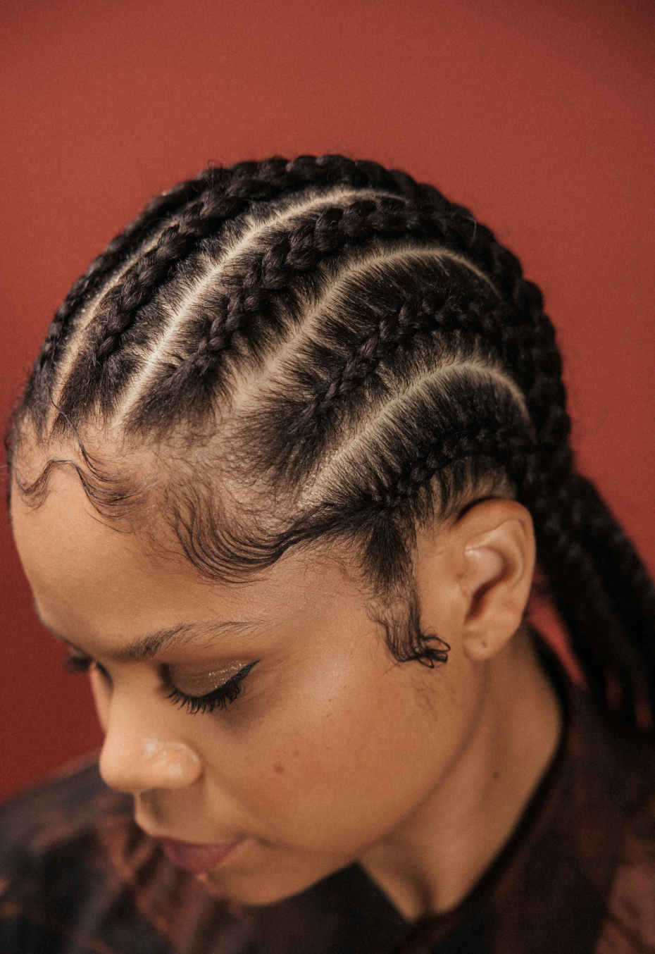 side profile of black woman with slicked edges wearing cornrows in hair