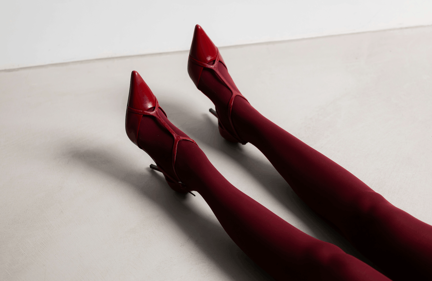 woman lying down wearing red tights and red heels
